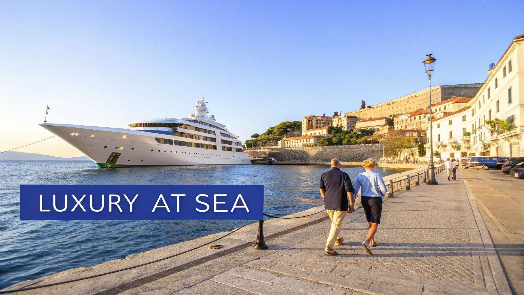 Couple walking past a majestic luxury yacht docked in a beautiful European coastal town.