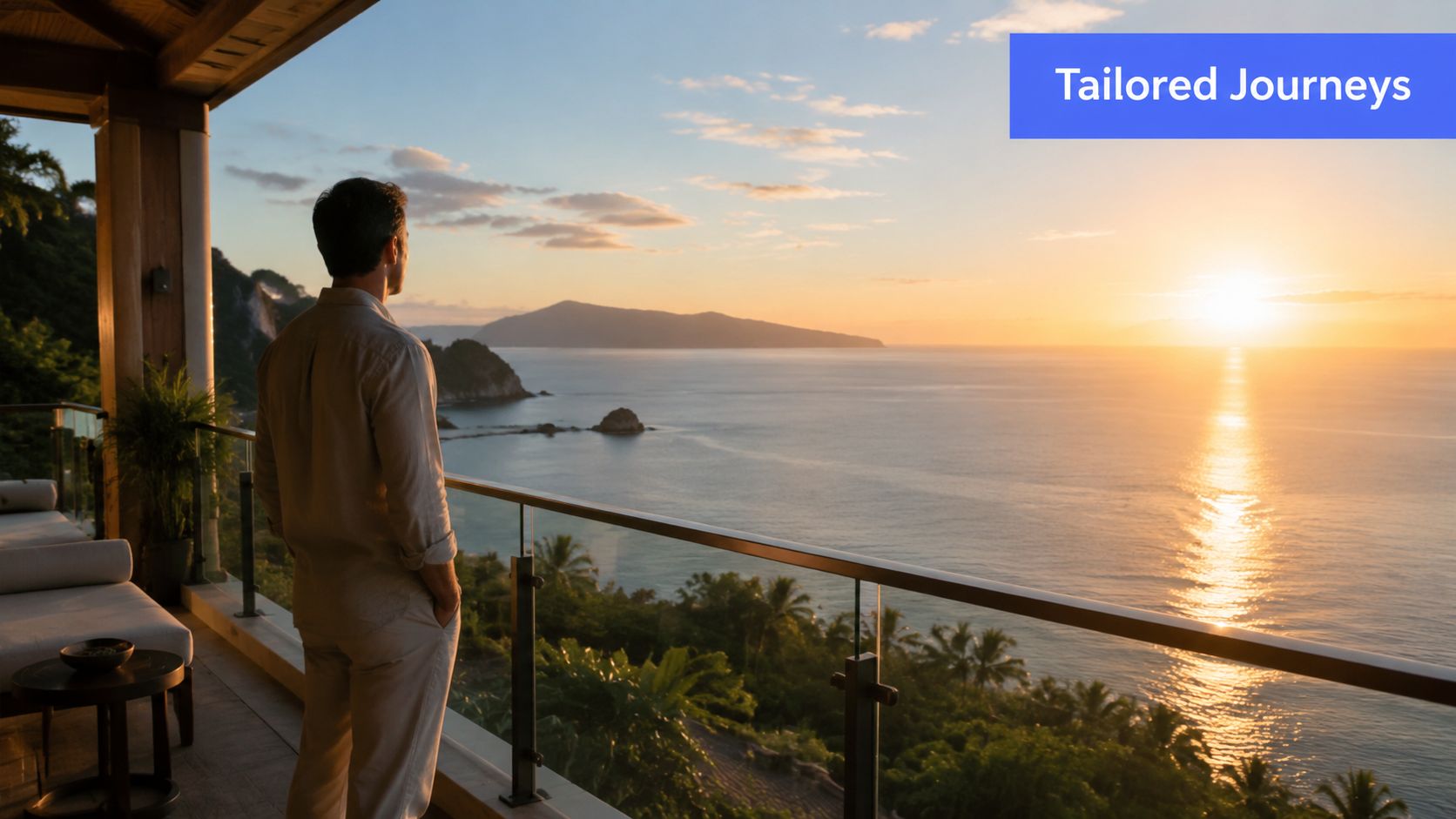A man stands on a luxurious hotel balcony overlooking a beautiful tropical sunset over the ocean.